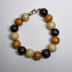 Beaded bracelet with brown, beige, and black beads on a light gray background